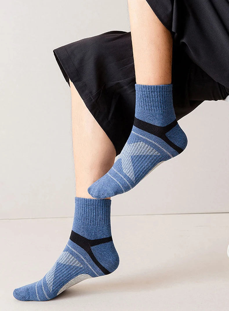 Person wearing blue socks with black accents on a light background